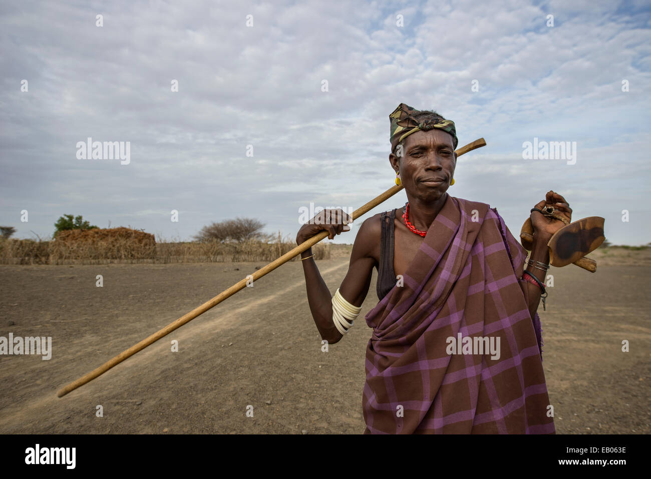 A Turkana warrior showing his cane and the neck piece for resting, Kenya Stock Photo