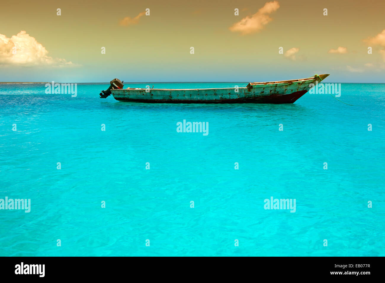 Wooden boat floating on the clear turquoise water of Zanzibar island