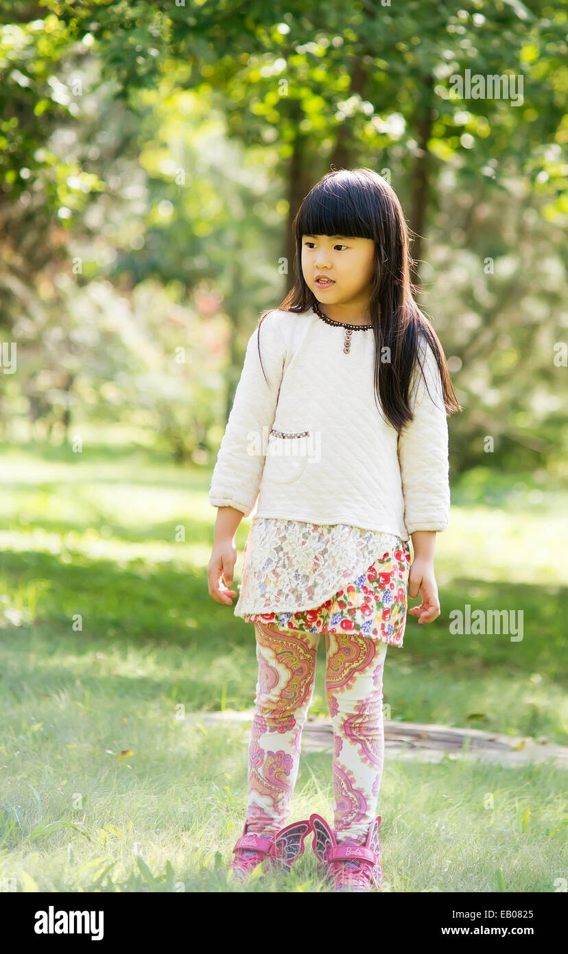 The little girl on the grass in the park Stock Photo