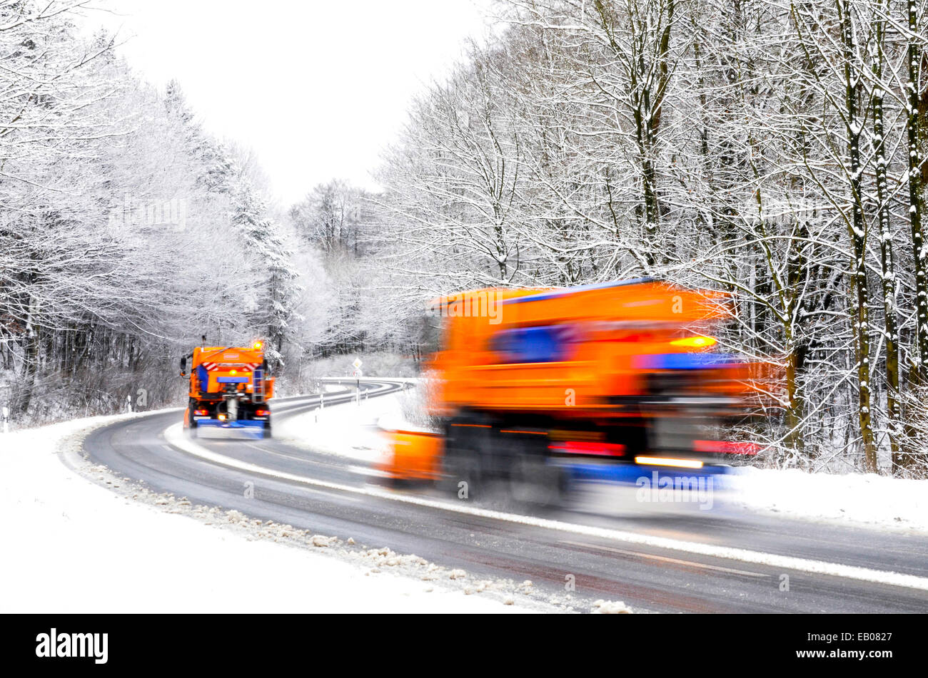 Two working snowplows on winter road, vehicles blurred Stock Photo