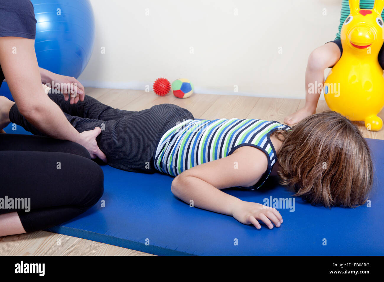 a female physiotherapist makes physiotherapy with young children Stock Photo