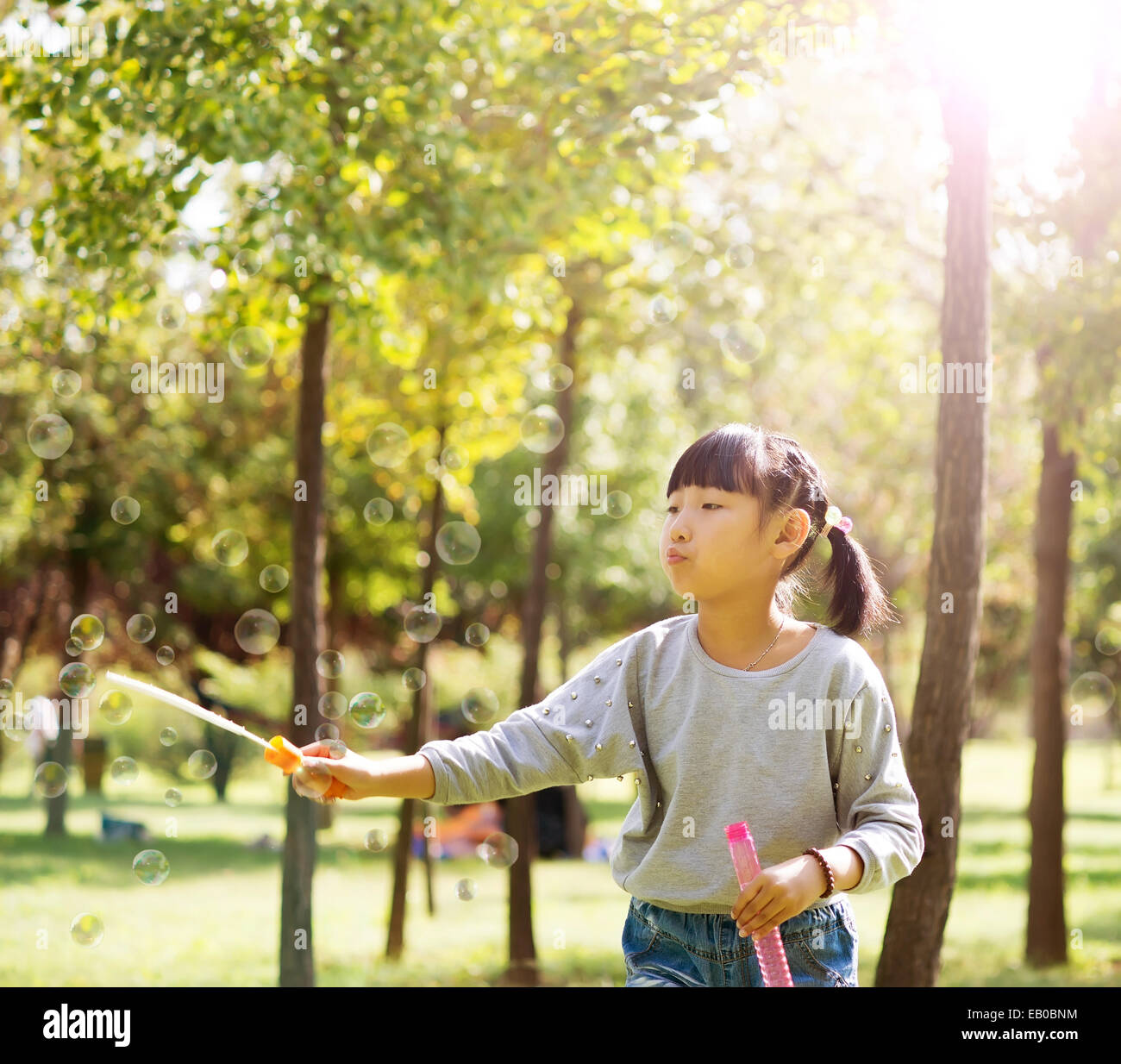 Portrait of a little girl blowing soap bubbles at the park Stock Photo ...