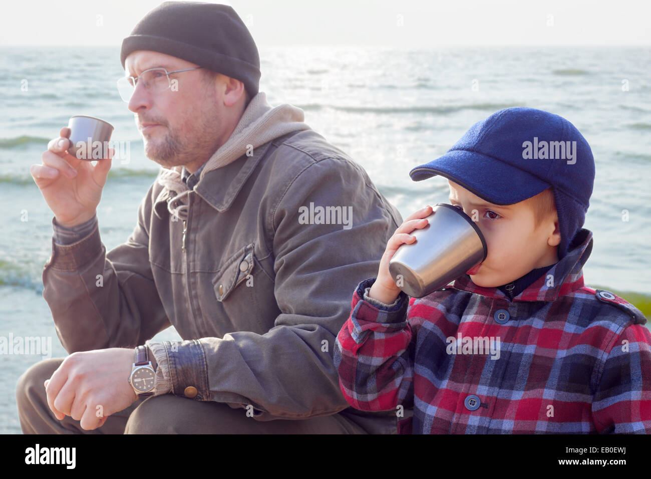 parent kid together drink tea coffee nature outdoor season Stock Photo