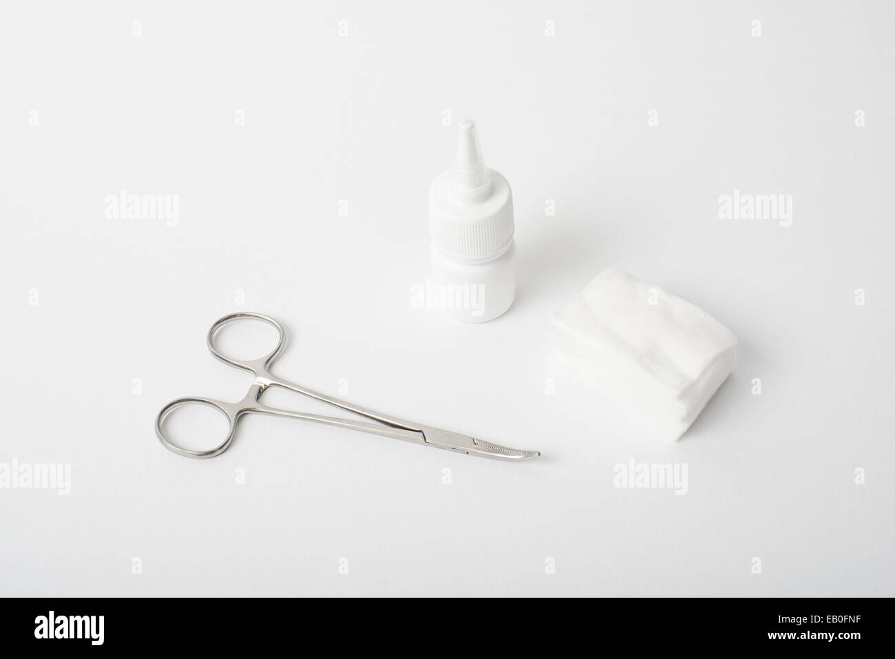 curved forceps with cotton and ointment on white background Stock Photo
