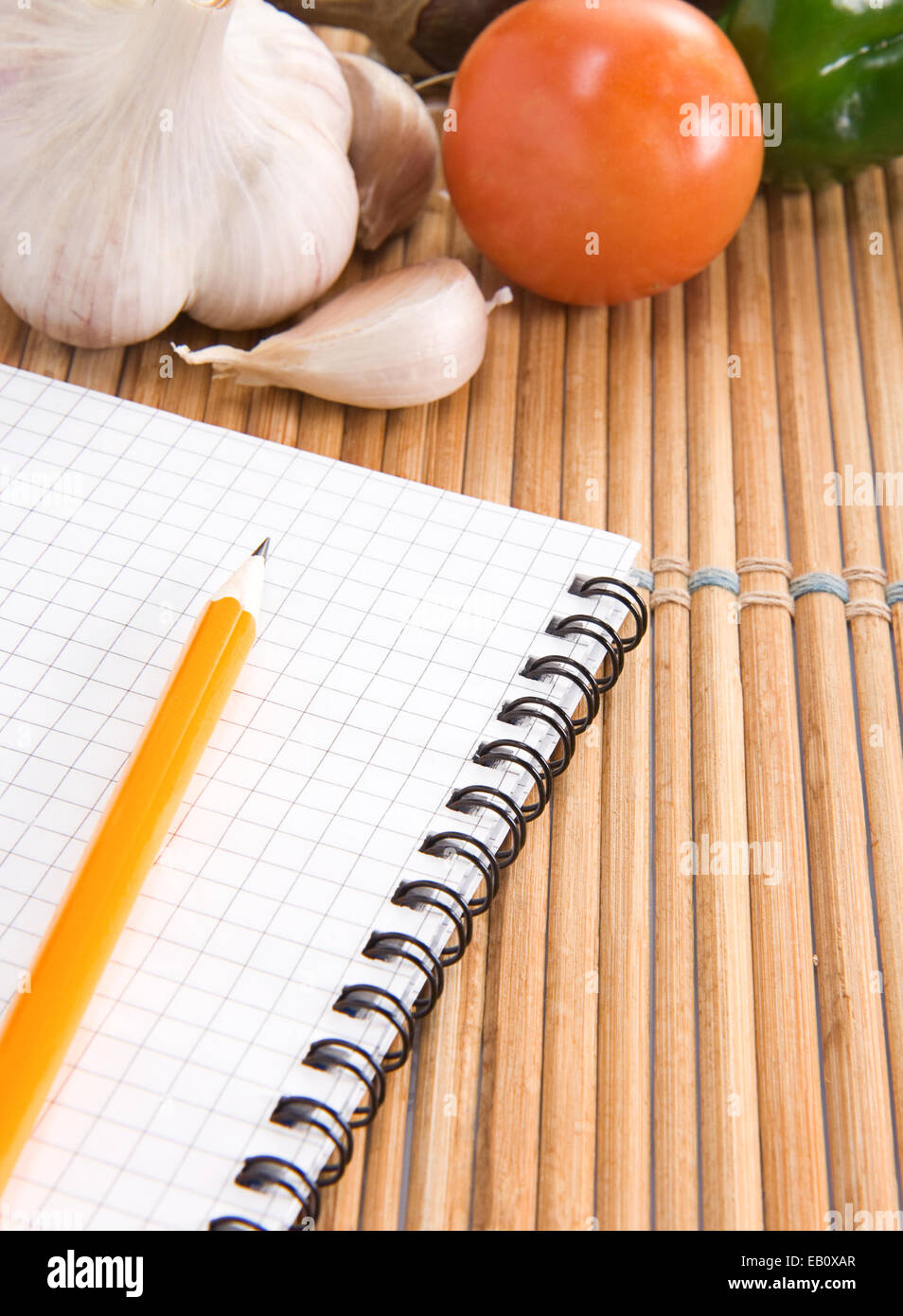notebook, garlic and tomato with pencil on straw in kitchen Stock Photo ...
