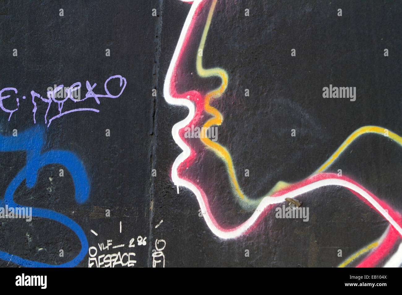 Berlin wall Street art Graffiti two faces tags Stock Photo