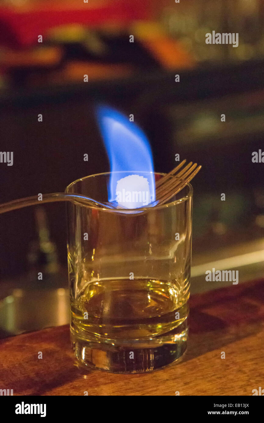 A burning sugar cube over a glass of absinthe exemplifying the French drip method. Stock Photo