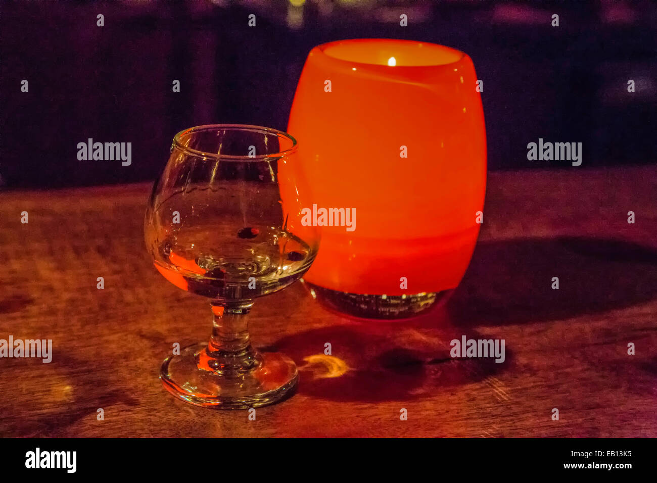 A single glass of liquor and a candle on a bar in Seattle, Washington
