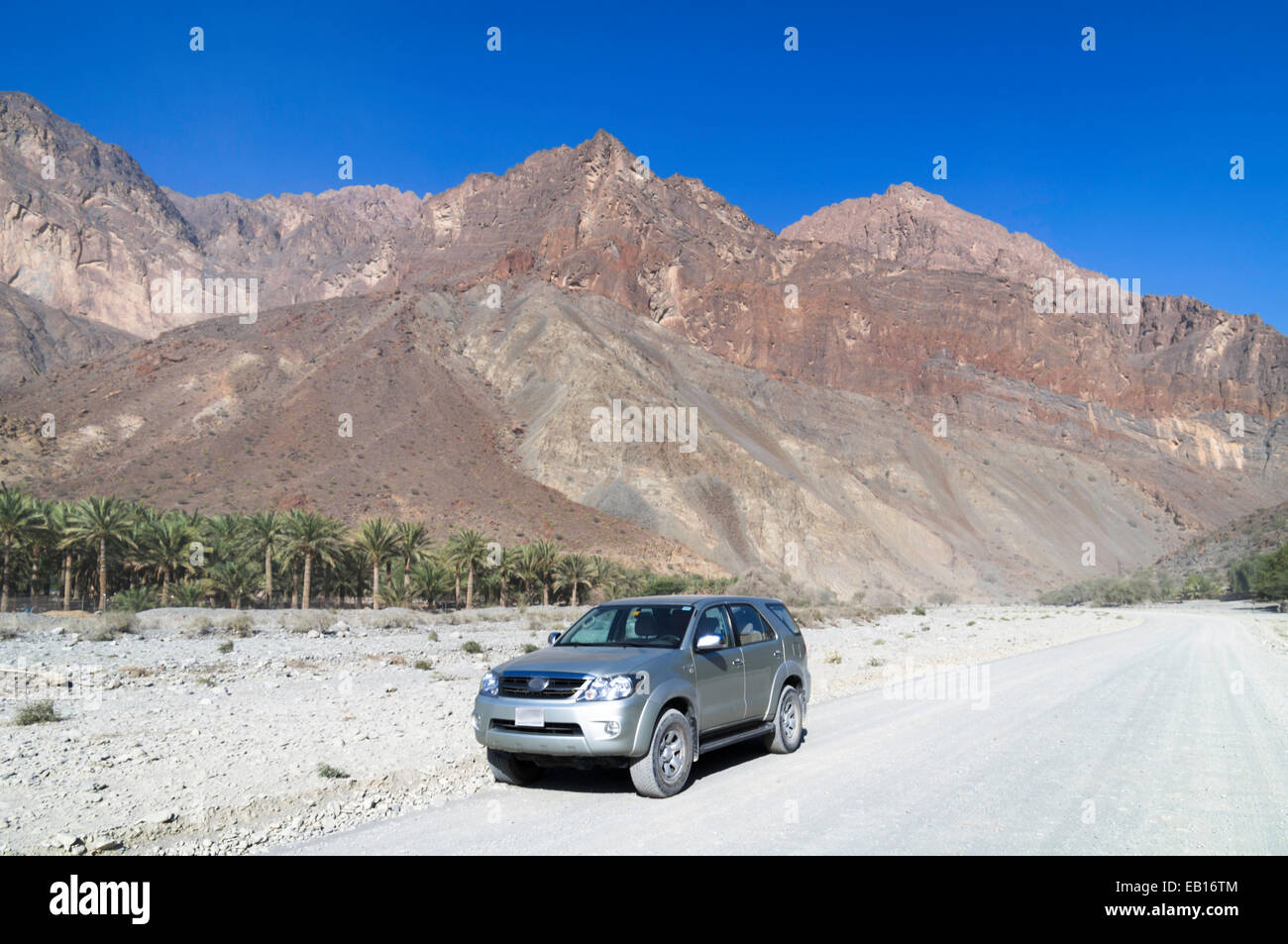 Car on road through Wadi As Sahtan in the Hajar Mountains, Oman Stock Photo