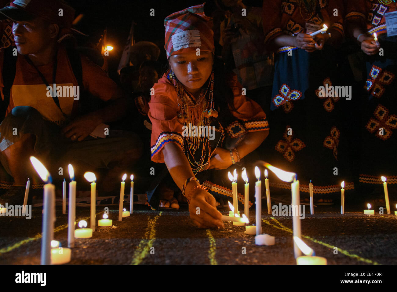 A young girl from a local tribe in Mindanao light up candles in front of the Redemptorist church in Baclaran, Paranaque. Hundreds of delegates from Mindanao, together with protest groups from southern Luzon held a candle lighting event in commemoration of the 5th anniversary of the Maguindanao massacre, where 58 people was murdered. 32 of the victims were journalists. © J Gerard Seguia/Pacific Press/Alamy Live News Stock Photo