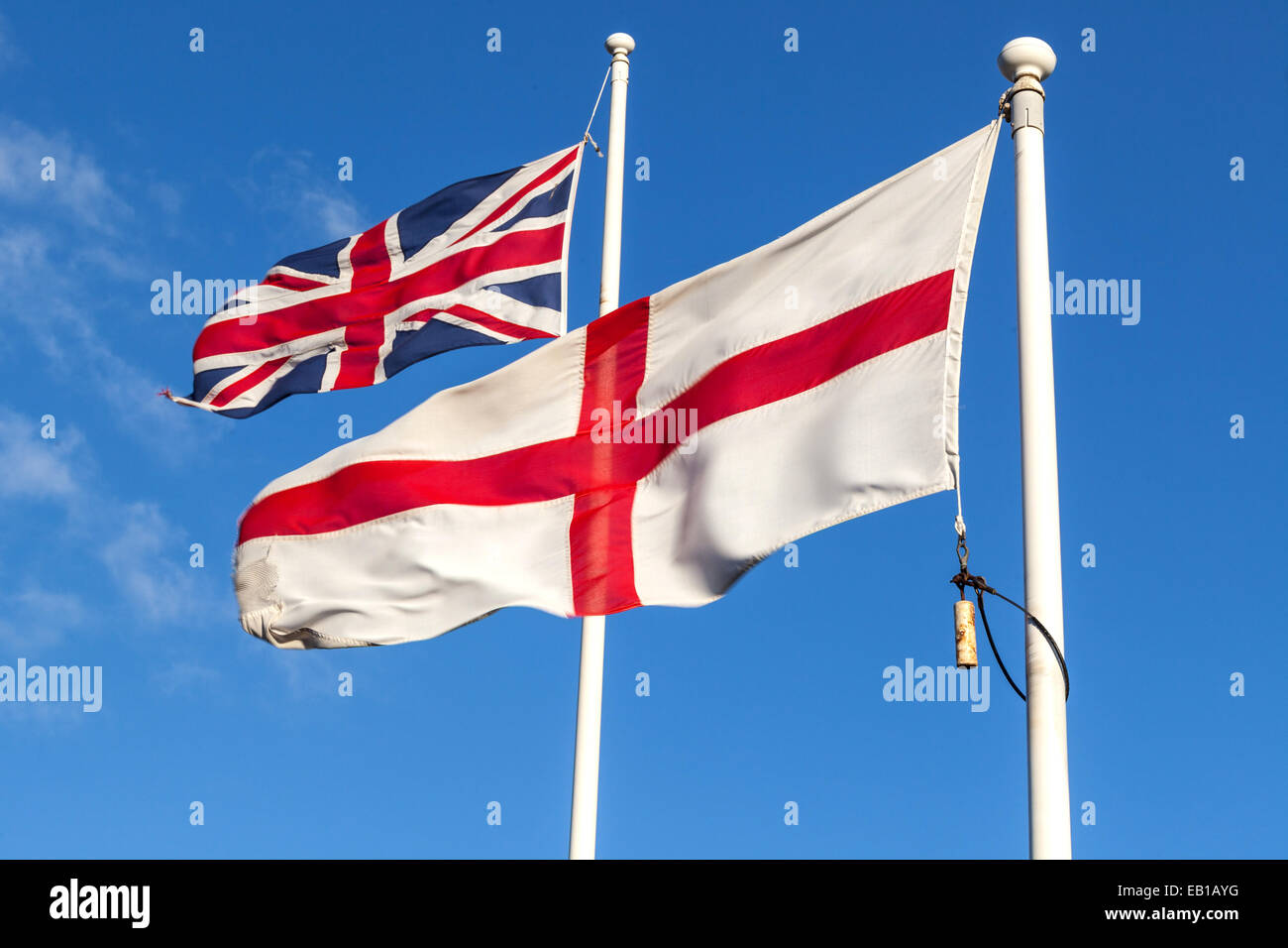 Union Jack and England flags blown by the wind on their respective flagstaffs, London, England, United Kingdom Stock Photo
