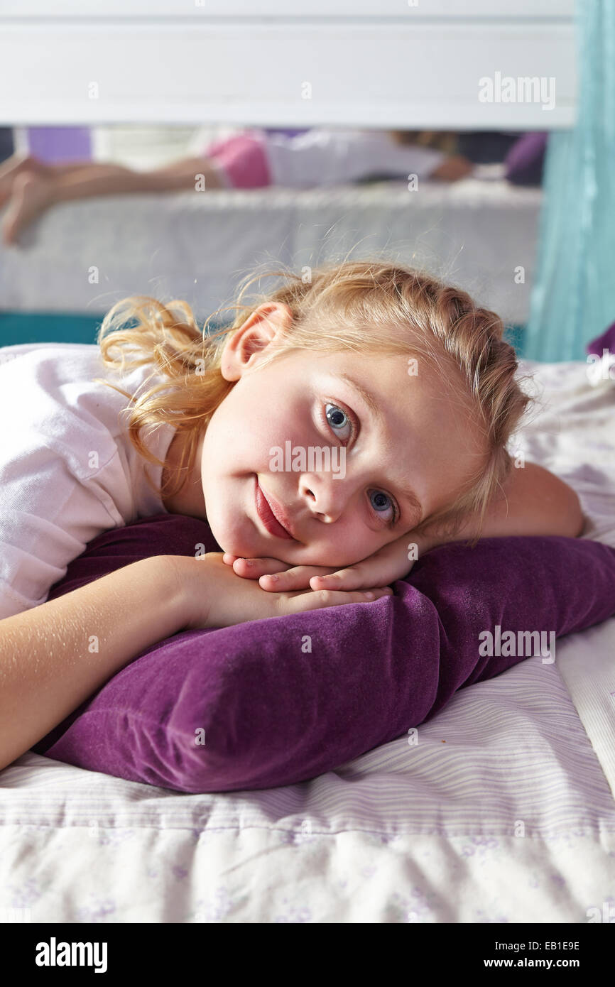 Young girl laying relaxed on a pillow in her nursery Stock Photo