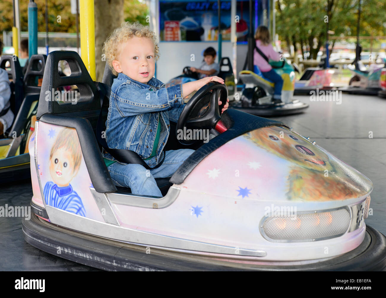 a little boy driving a bumper car at the carnival Stock Photo Alamy