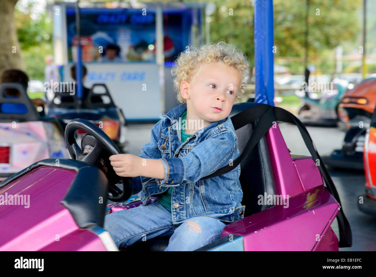 a little boy driving a bumper car at the carnival Stock Photo Alamy