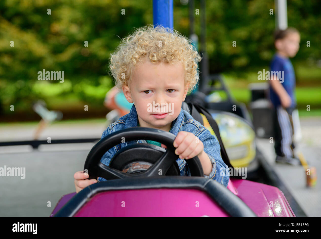 a little boy driving a bumper car at the carnival Stock Photo Alamy