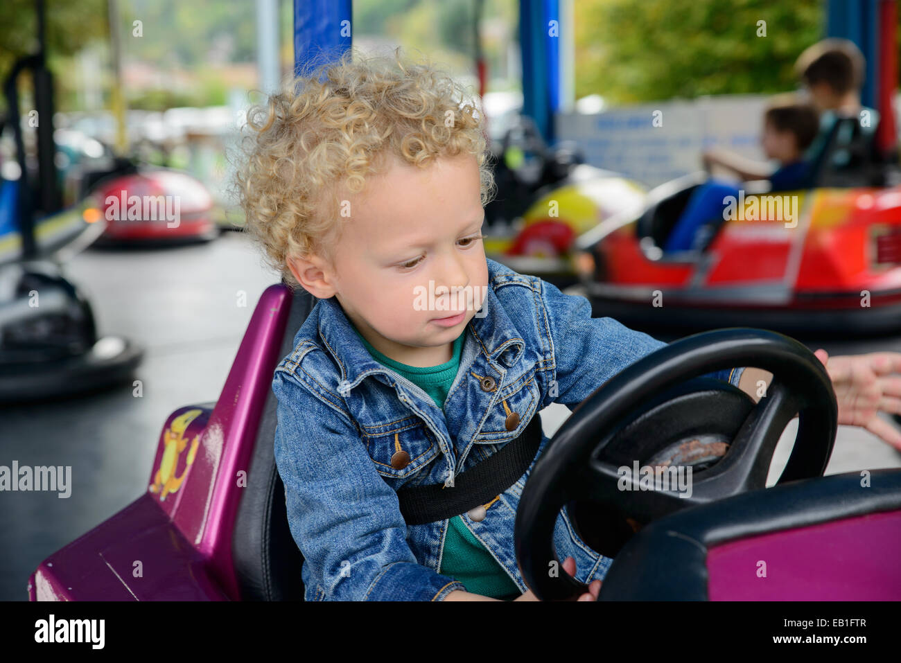 a little boy driving a bumper car at the carnival Stock Photo Alamy