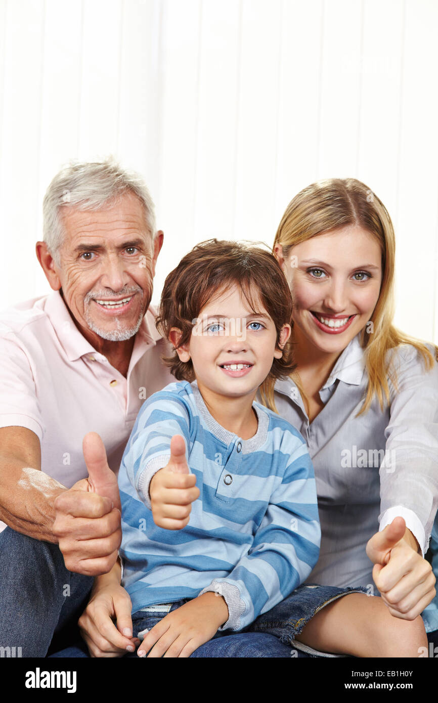 Happy family in living room holding thumbs up for congratulations Stock Photo
