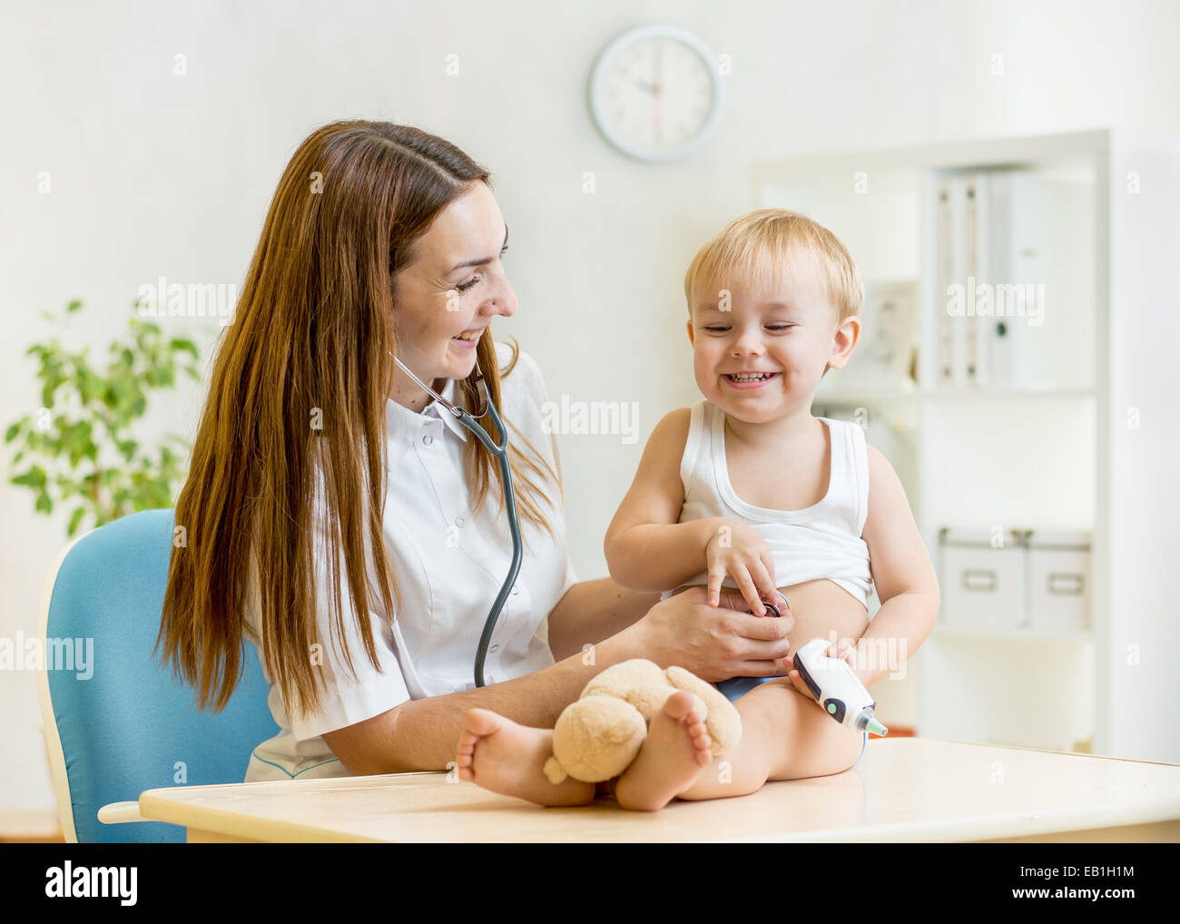 pediatrician doctor examining of kid with stethoscope Stock Photo