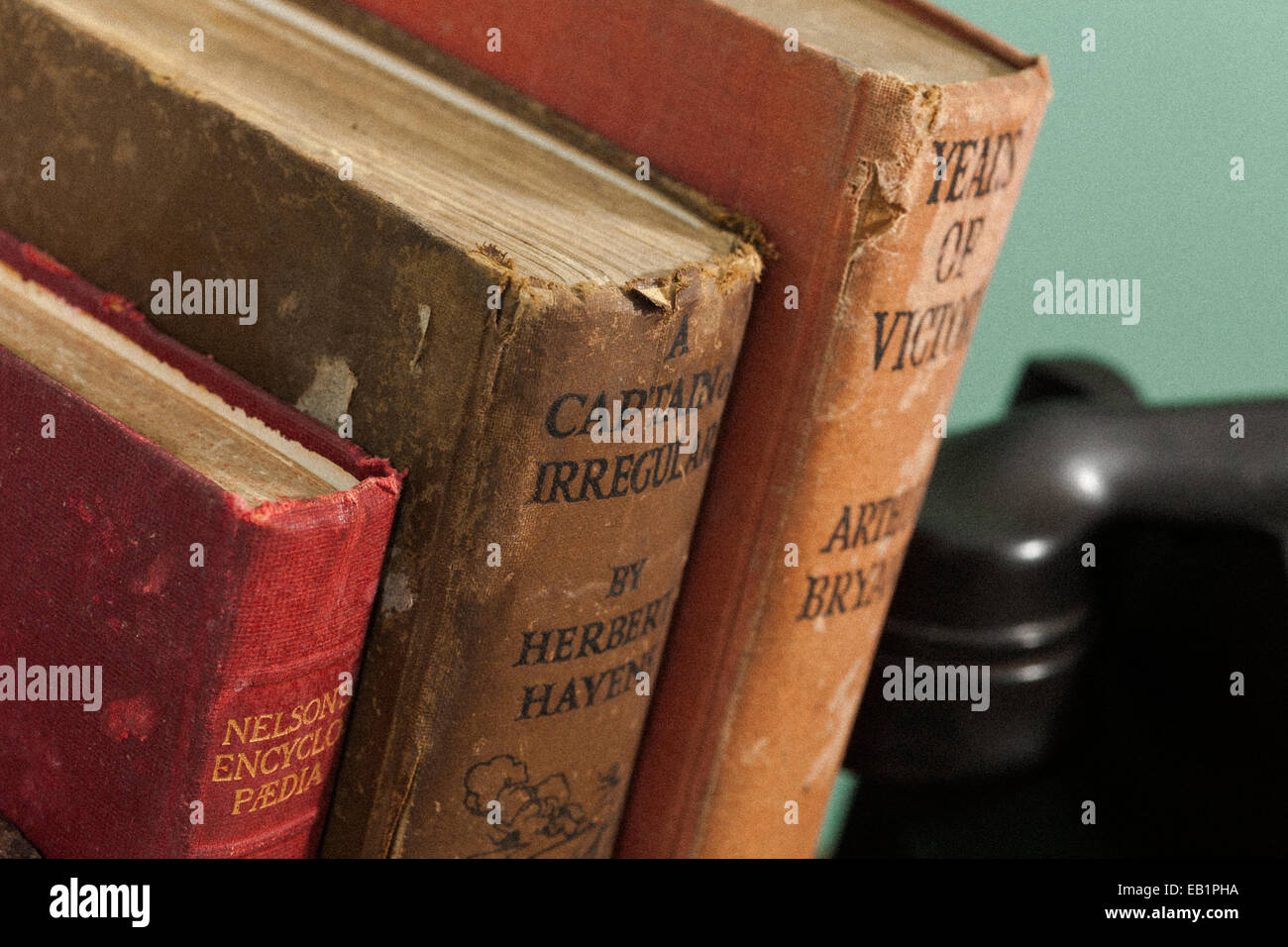 Vintage books against green wall with telephone in background Stock Photo