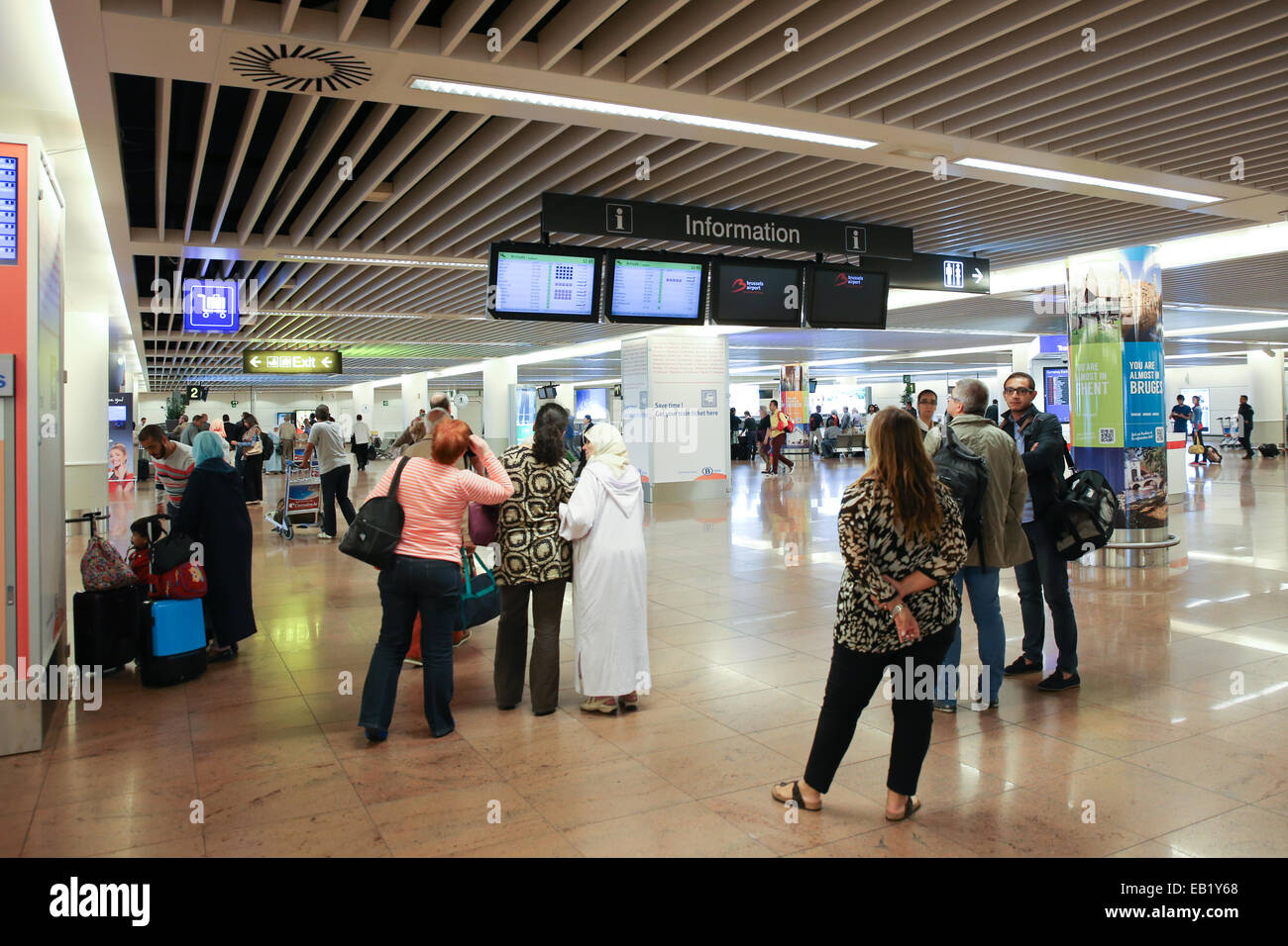 travelers checking flight information display board Stock Photo