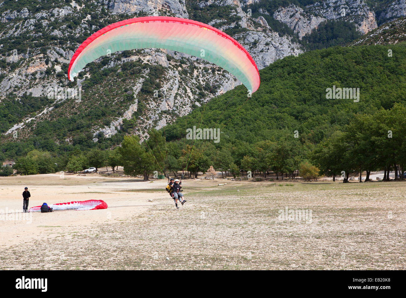 two people with a glider prepare for landing Stock Photo