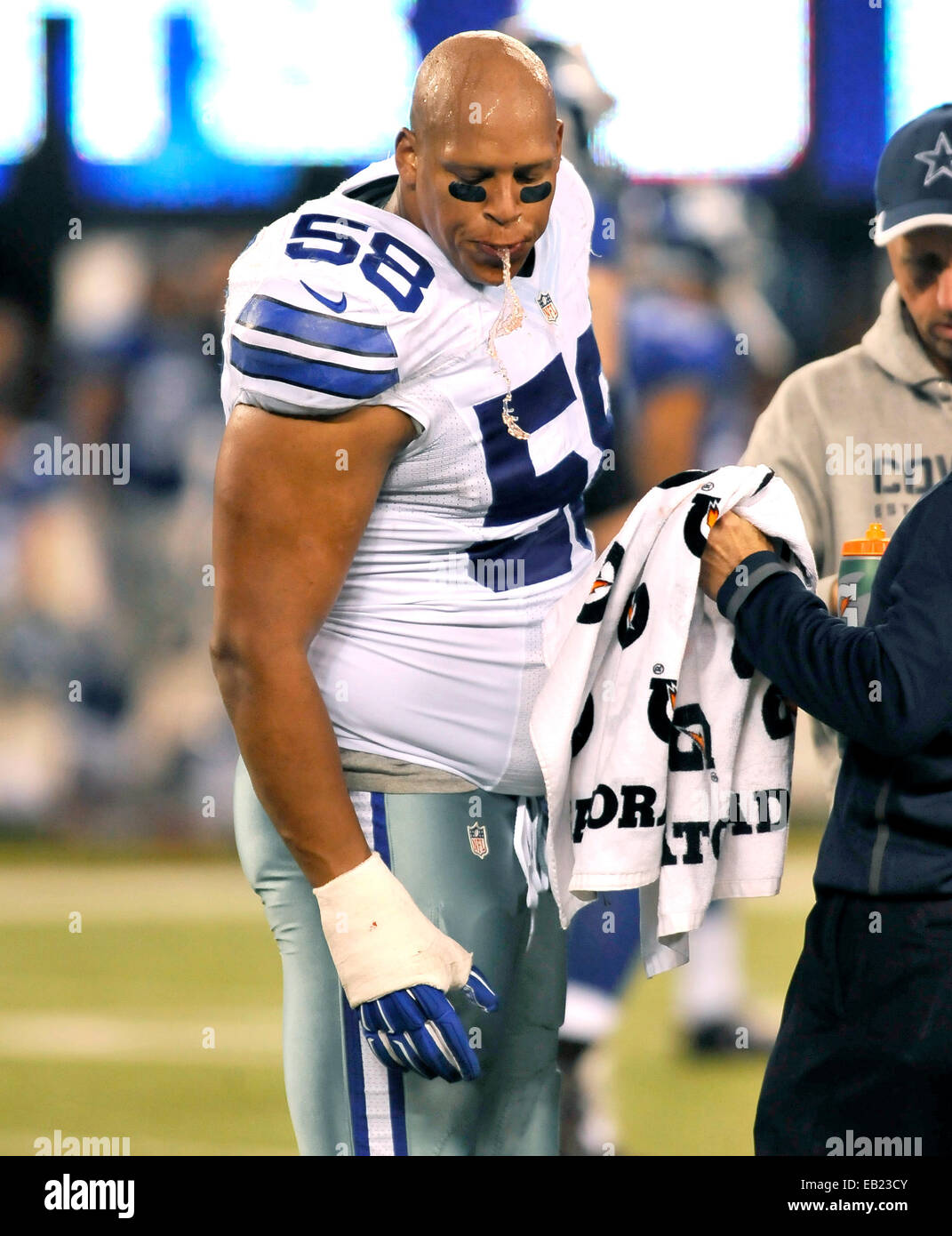 East Rutherford, New Jersey, USA. 23rd Nov, 2014. Cowboys' defensive end Jack  Crawford (58) is attended to by team trainer in the second half during NFL  action between the New York Giants