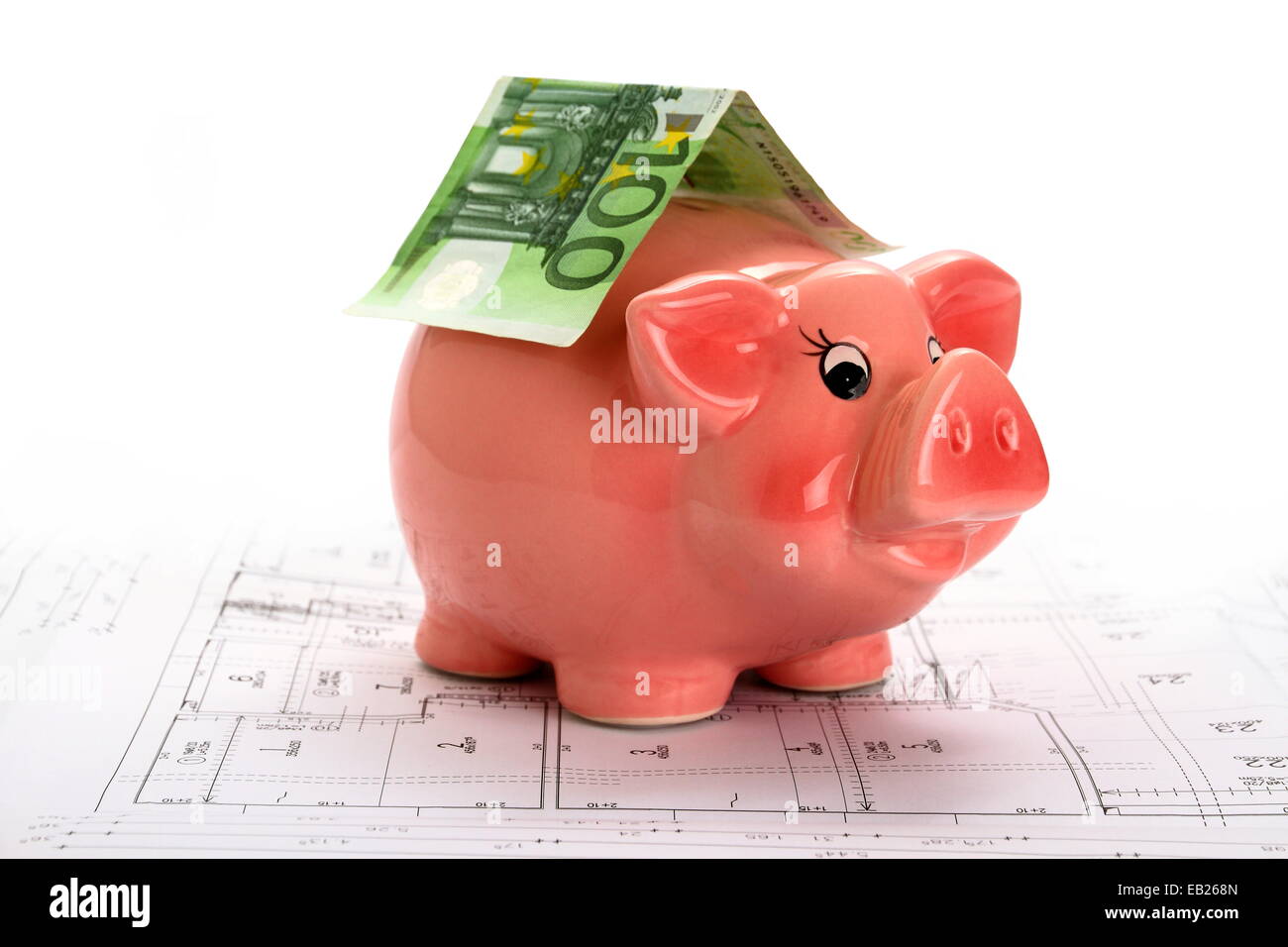 Pink piggy bank with euro banknote on house drawing, white top ...