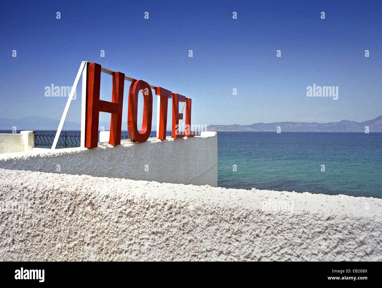 Red Hotel Sign Against A Blue Sky And The Mediterranean Sea - 