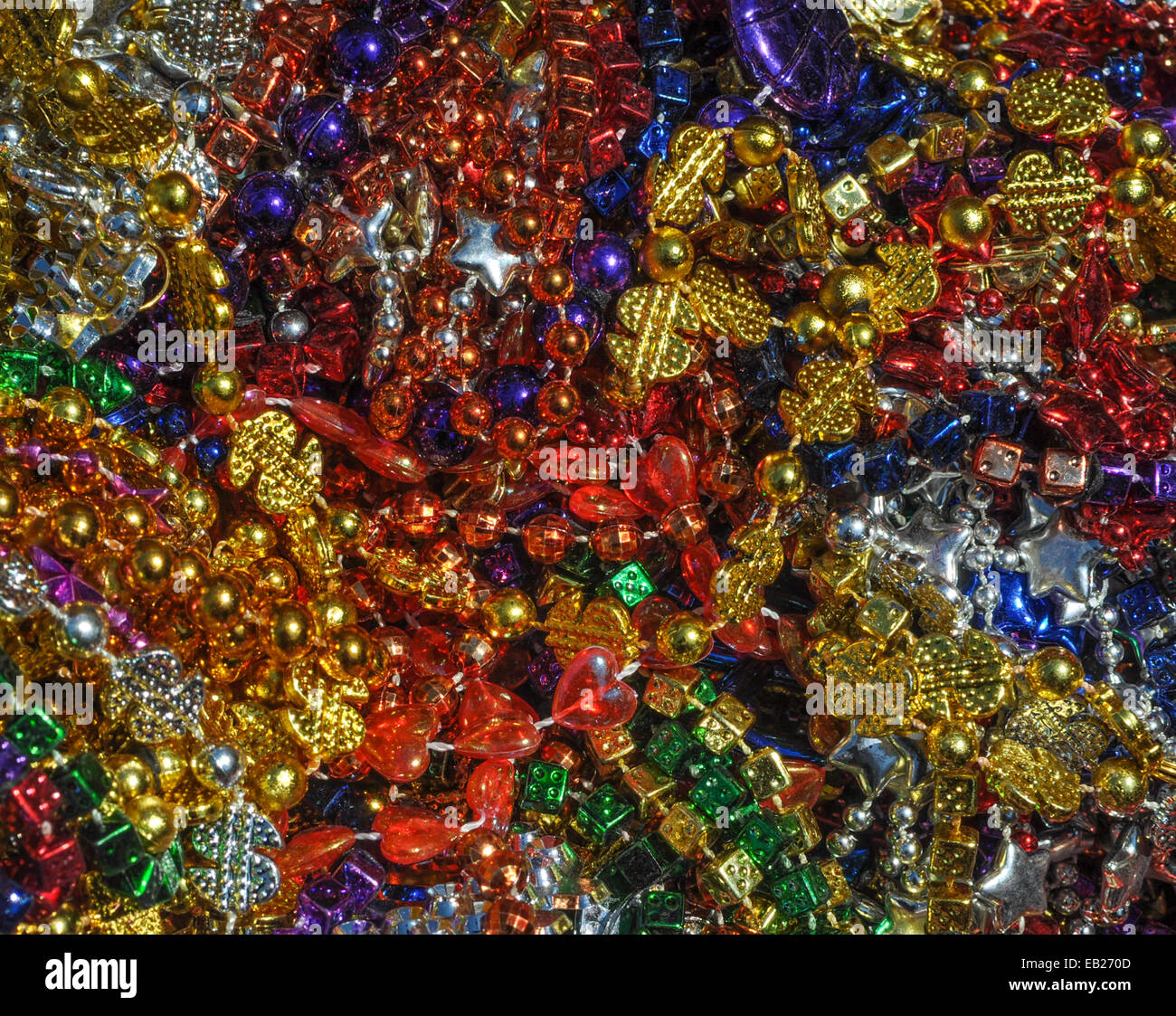 Background made up of mulit-colored including gold, purple, blue, green and pink mardi gras beads Stock Photo