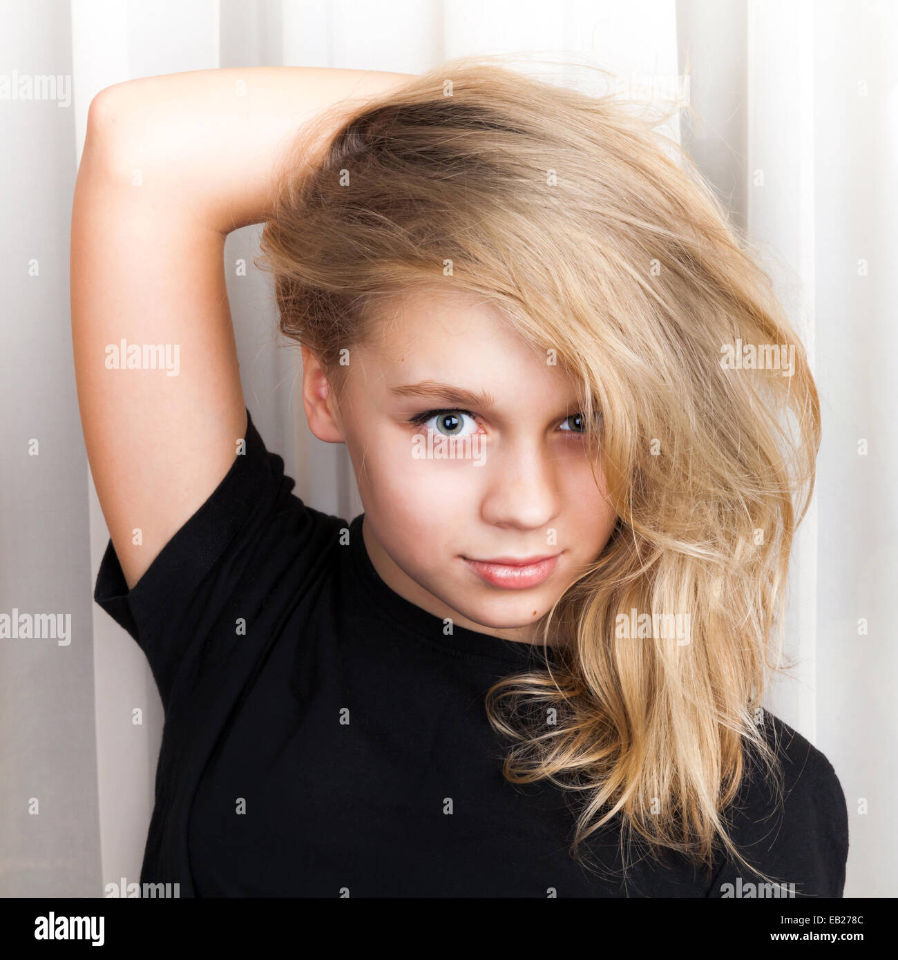 Smiling Caucasian girl with long blond hair, close up studio portrait Stock Photo