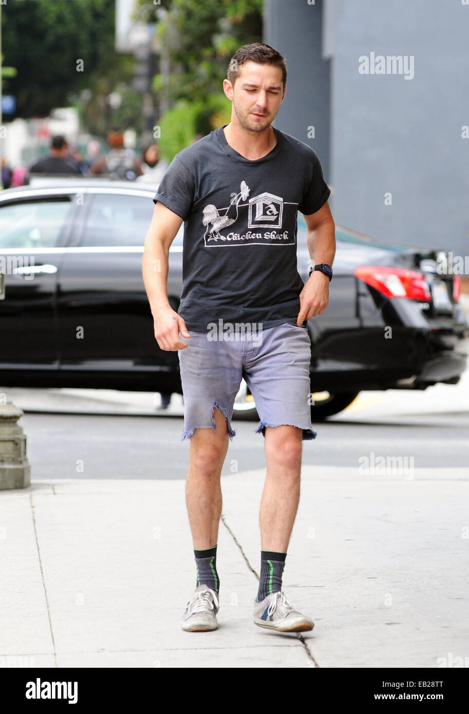 Shia LaBeouf dressed down wearing ripped cut off jeans, Chicken Shack  t-shirt and socks with his sneakers as he goes on errands out and about in  West Hollywood Featuring: Shia LaBeouf Where: