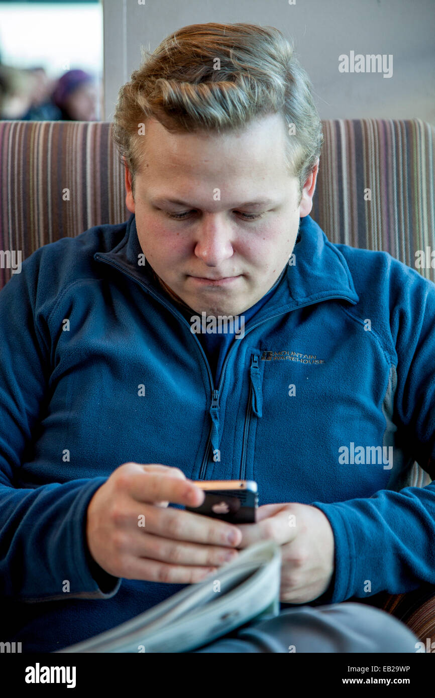 Young Man Reading His Texts, Heathrow Airport, London, England Stock Photo