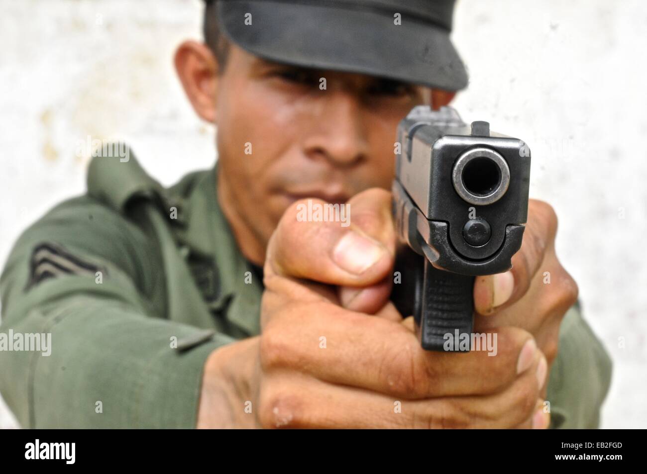 Uniformed police officer aiming a pistol at a tactical and firearms training  course at the Panamanian National Police Force Academy Stock Photo - Alamy