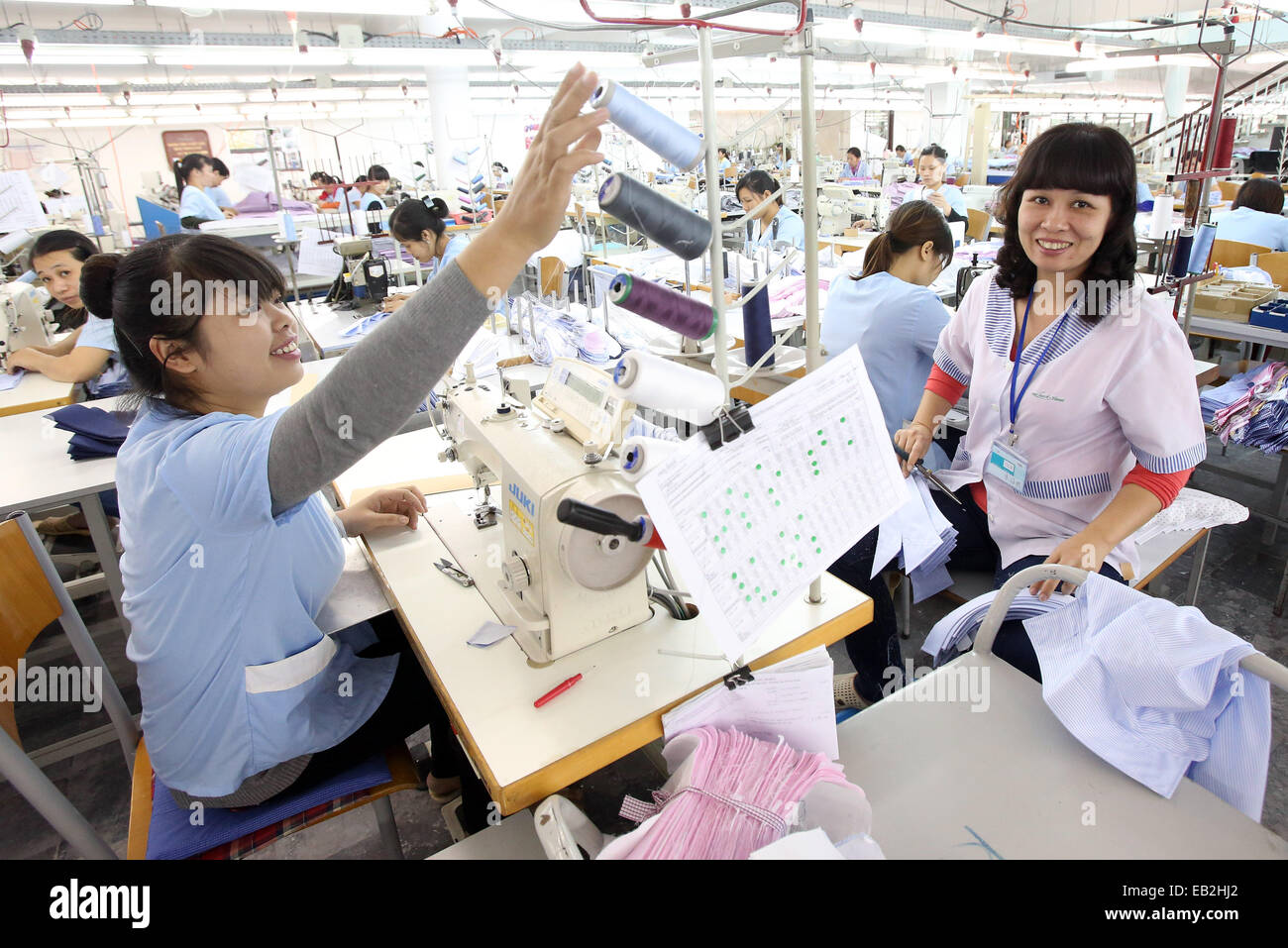 Hanoi, Vietnam. 20th Nov, 2014. Employees sit at sewing machines in a