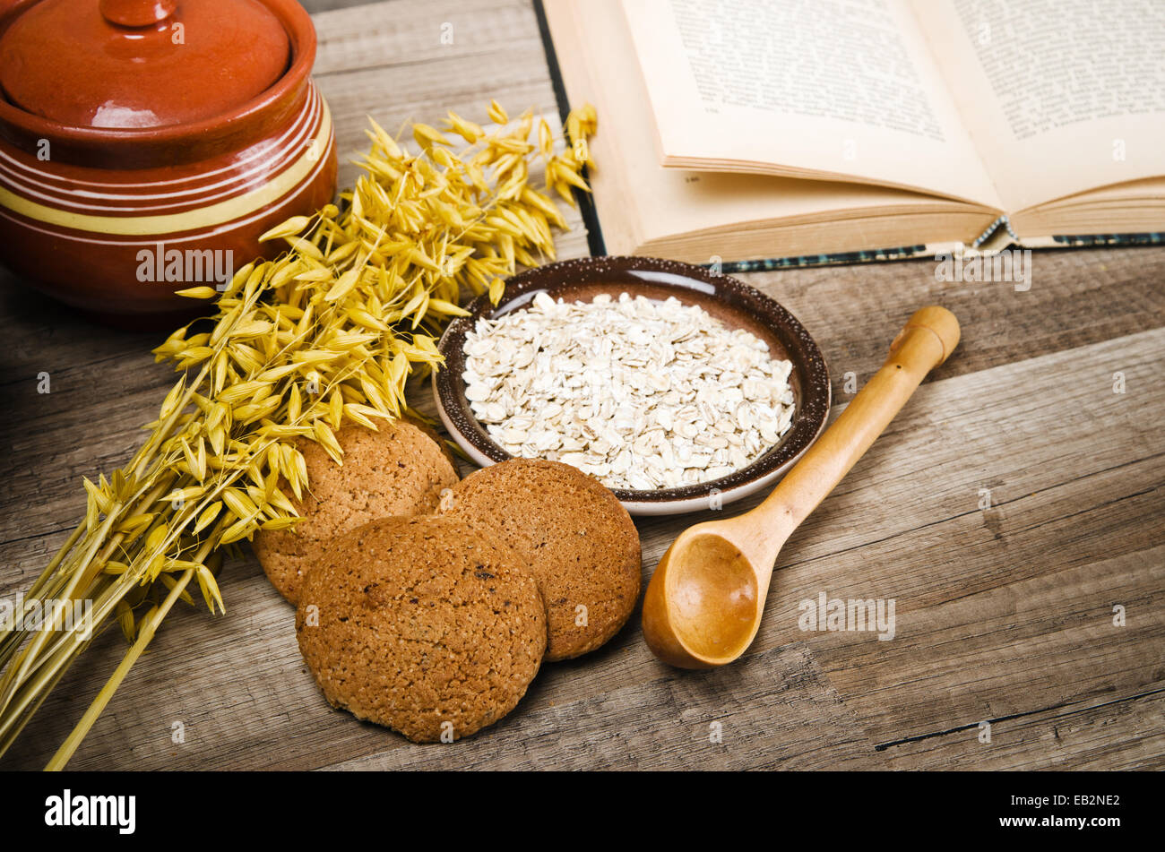 Oatmeal cookies, open book of recipes and cooking utensils Stock Photo