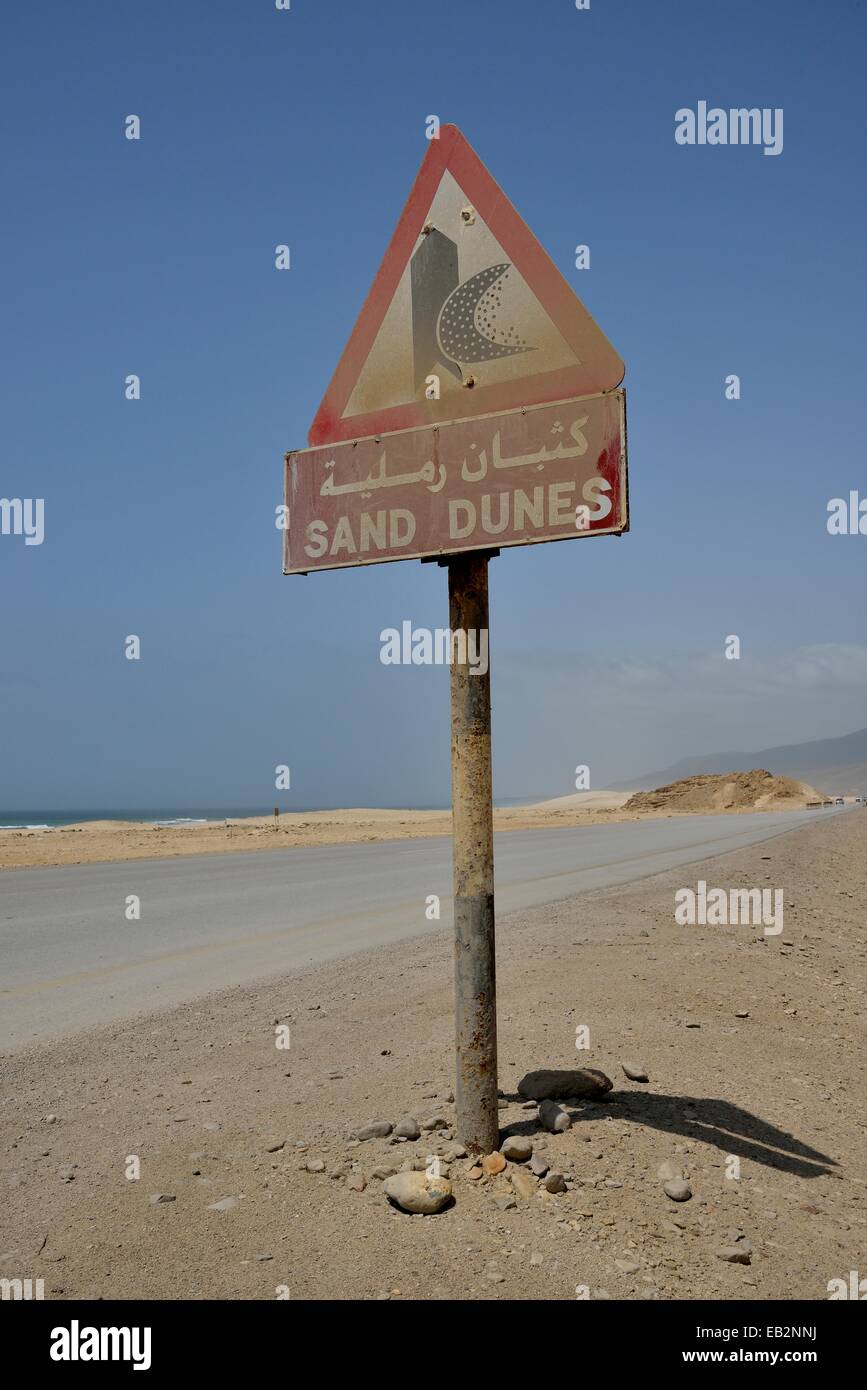 Warning sign warns of sand dunes, near Mirbat, Dhofar Region, Oman Stock Photo