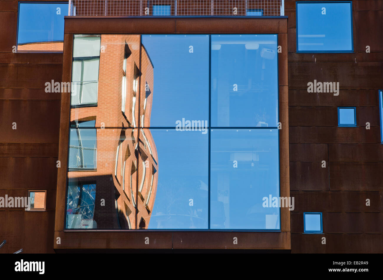 houses and blue sky reflected in windows of modern office building ...