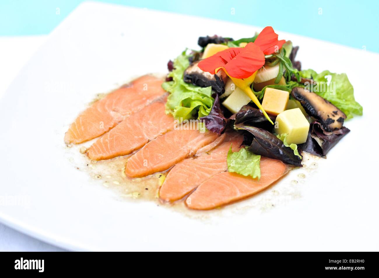 Salmon carpaccio with salad Healthy salad with corn, mushrooms, cheese, tomato and lettuce. Stock Photo