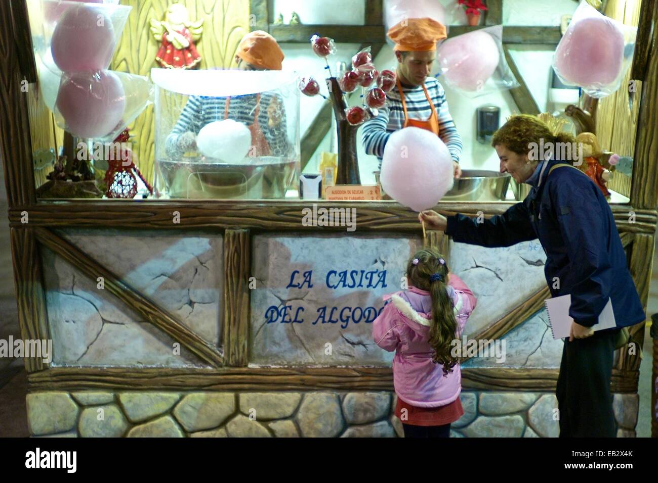 A happy girl waits for her cotton candy at a stall outside the Basilica-Cathedral of Our Lady of the Pillar in Zaragoza. Stock Photo