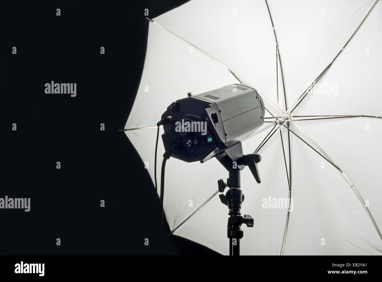 Photography Studio Flash Head with Umbrella and dark black copy space. Stock Photo
