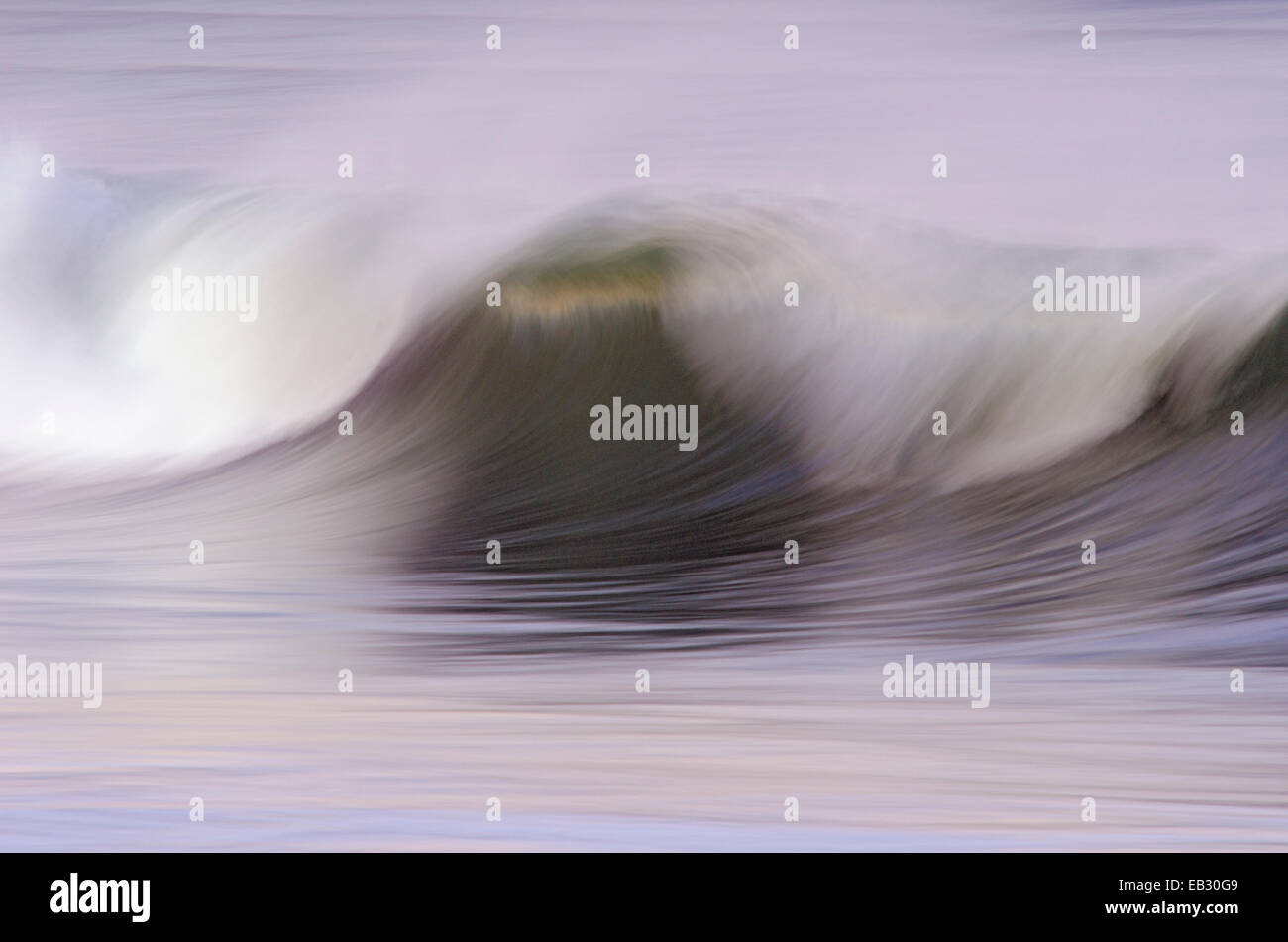 Motion of a wave breaking at sunrise in Ventura Harbor, California. Stock Photo