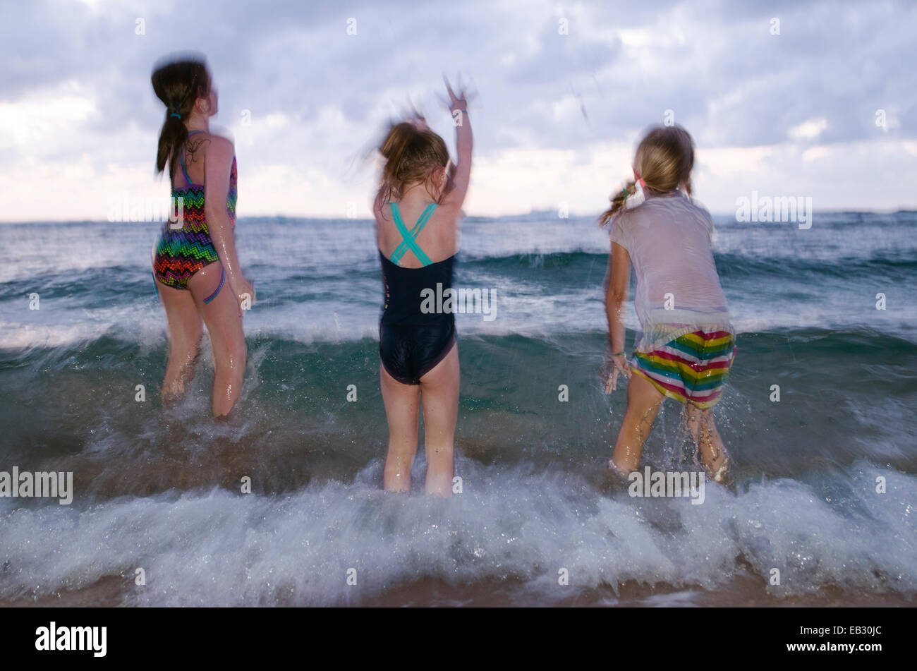 Three girls play in the water at Ke'e Beach on the Na Pali Coast. Stock Photo