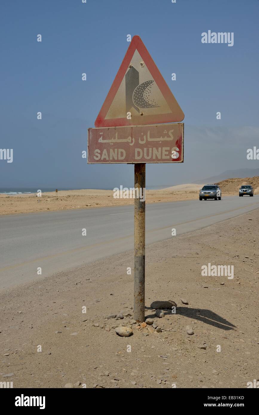 Warning sign warns of sand dunes, near Mirbat, Dhofar Region, Oman Stock Photo