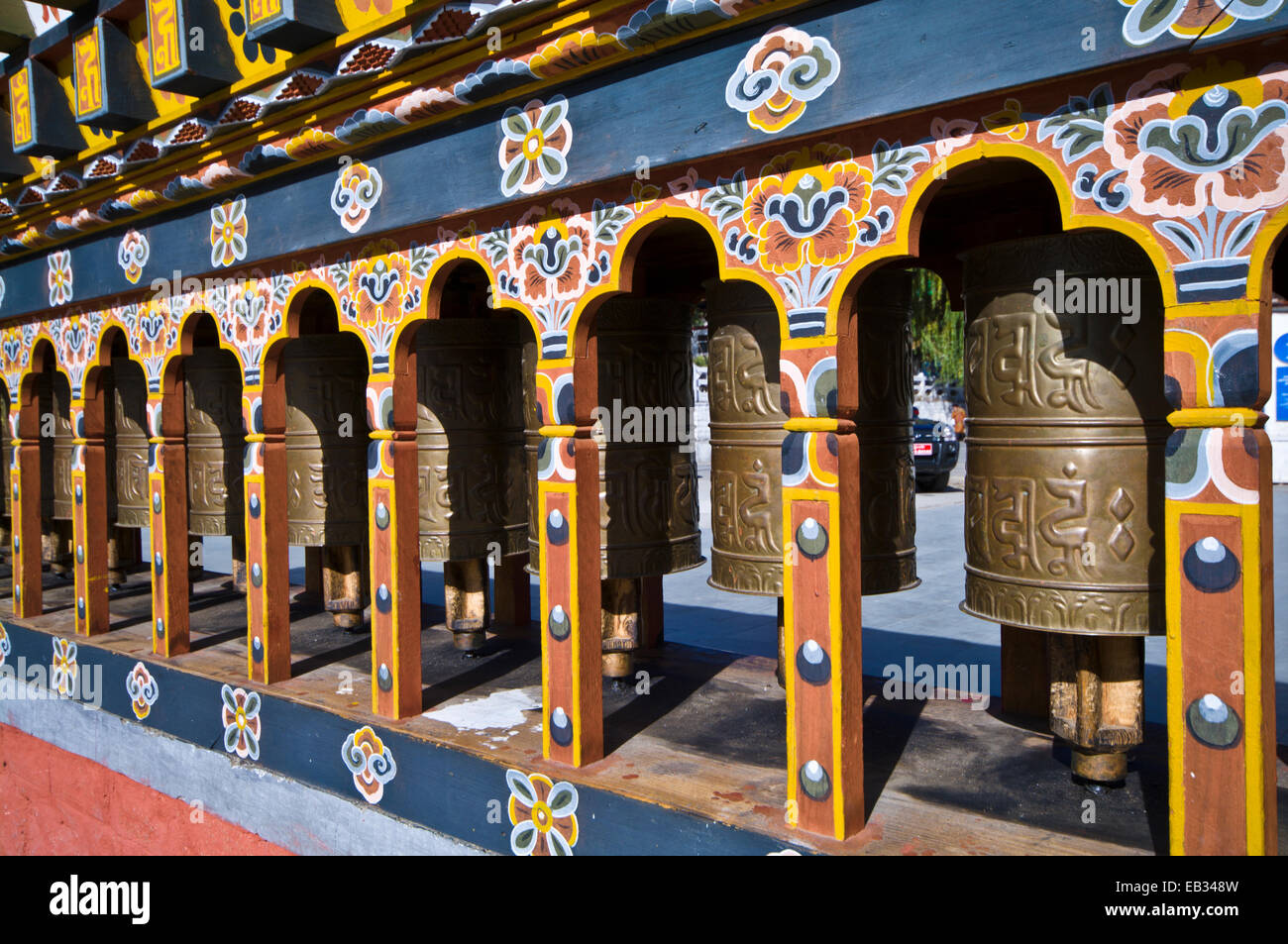 Religious symbols on a spinning brass prayer wheels in a Himalayan town square. Stock Photo