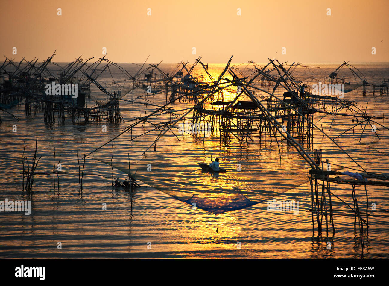 Thailand, Phatthalung, Chinese fishing nets installed in sea shoals at sunrise Stock Photo