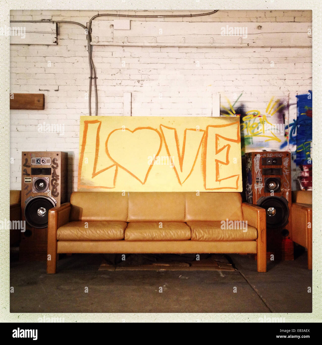 Love sign over sofa against brick wall - Smartphone Captured Stock Image