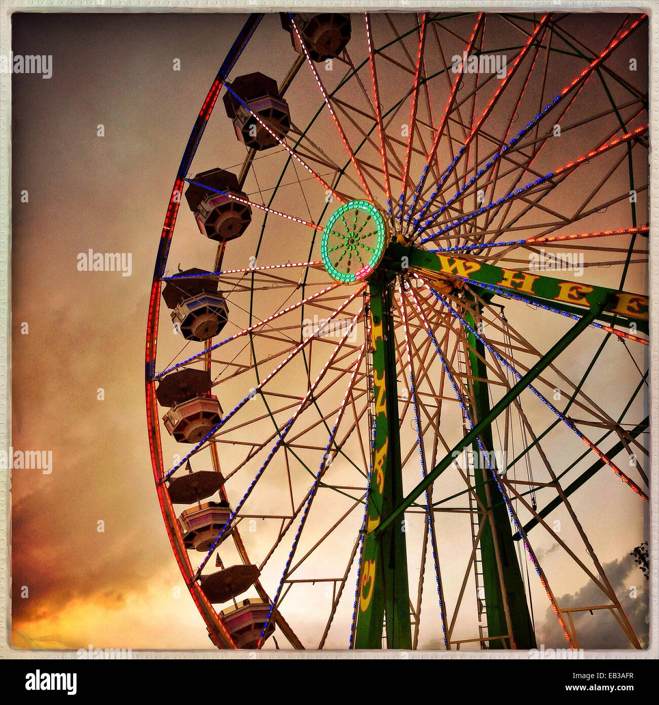 Low angle view of ferris wheel under dramatic sunset sky - Smartphone Captured Stock Image