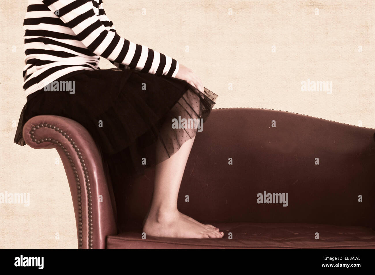 Girl sitting barefoot on sofa hi-res stock photography and images - Alamy