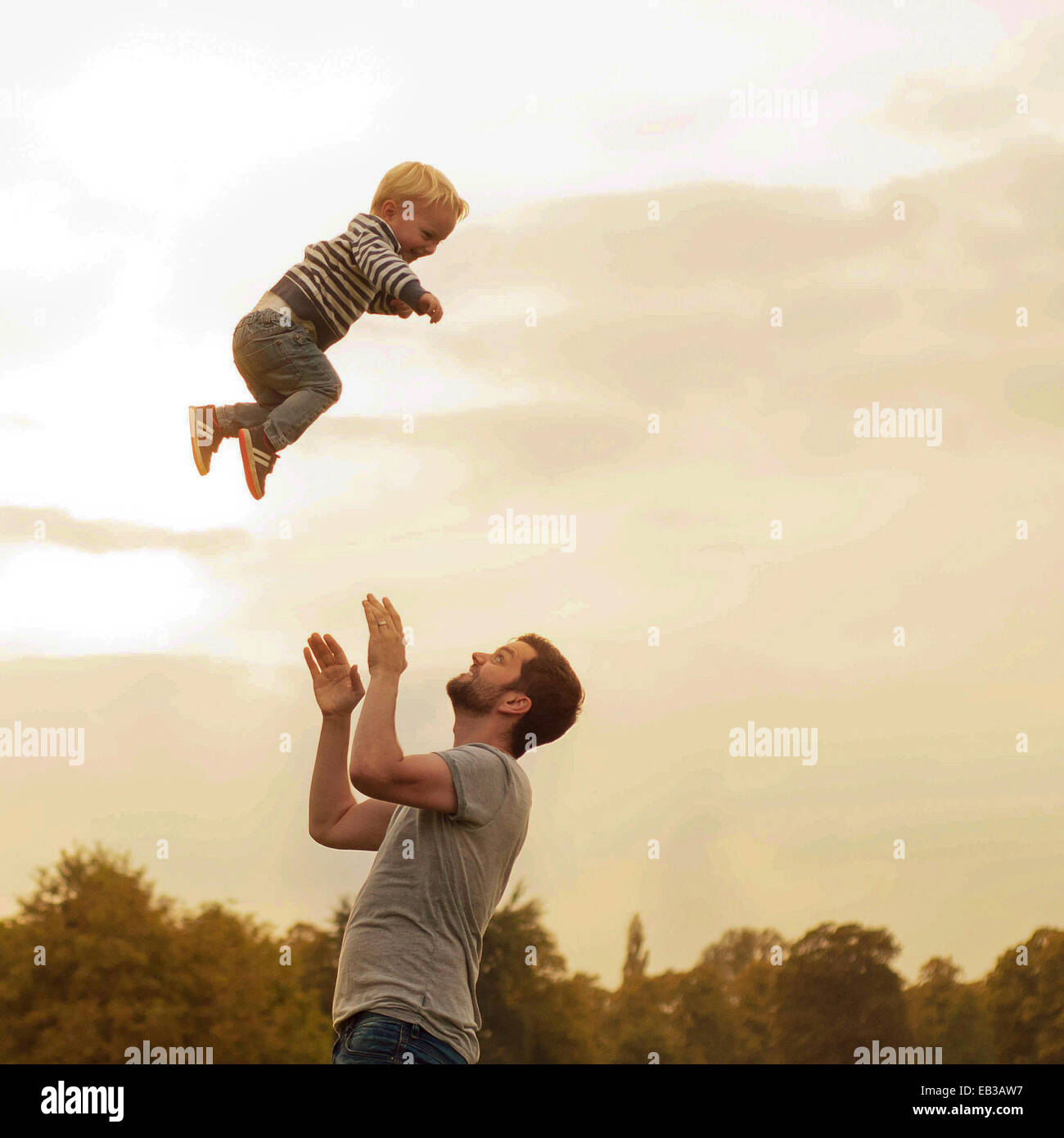 Father throwing son into air Stock Photo Alamy