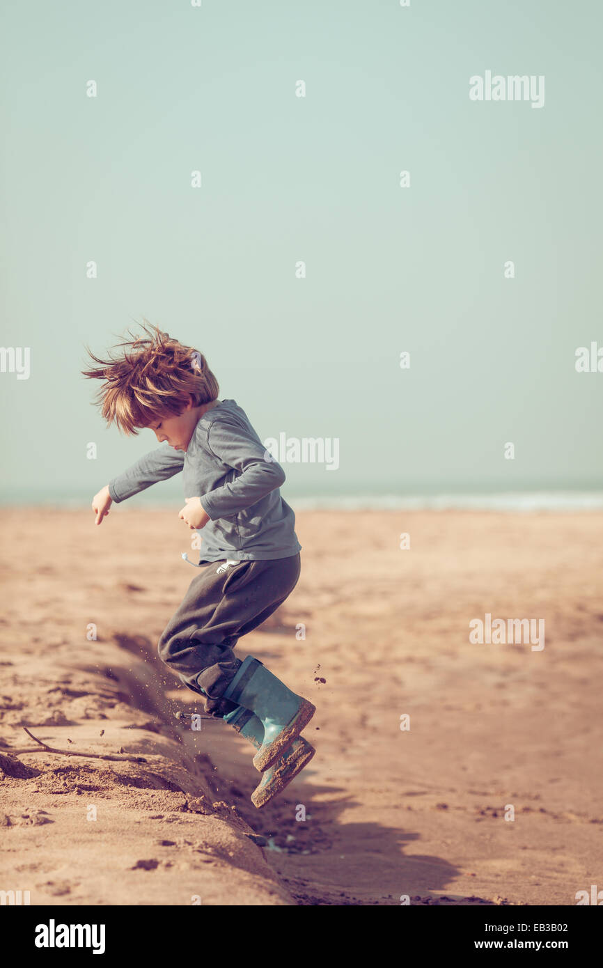 Boy jumping in the sand on the beach, Morocco Stock Photo Alamy